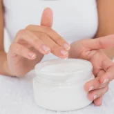 close-up-mid-section-of-woman-applying-cream-over-PJ88FD9.jpg